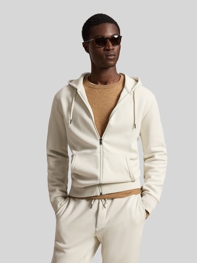 Männermodel trägt Regular Fit Sweatjacke aus Baumwoll-Mix von Polo Ralph Lauren in Creme mit Reißverschluss, beiger Pullover, Ganzkörperansicht von vorne.