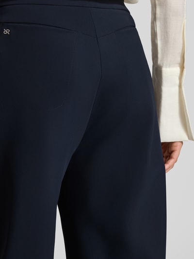 Frauenmodel trägt Stoffhose in verkürzter Passform Modell 'ODINE' von Raffaello Rossi, Material-Mix mit Stretch-Anteil, dunkelblau, Detailaufnahme Rückansicht.