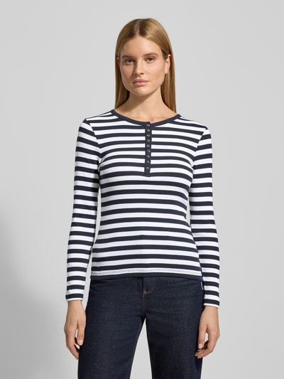 Vrouwenmodel draagt Shirt met lange mouwen met korte knoopsluiting van Christian Berg Woman, mix van biologisch katoen, slim fit, ronde hals, donkerblauw-wit gestreept, ruglengte maat S 55 cm, voorkant volledige lichaamsweergave.