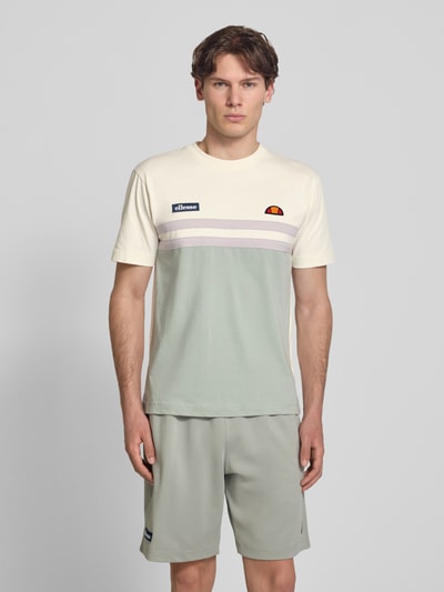 Männermodel trägt T-Shirt mit Label-Stitchings und Rundhalsausschnitt von ellesse, Reine Baumwolle, Regular-Fit, Rückenlänge 69 cm, Ganzkörperansicht von vorne.