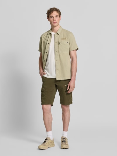 Männermodel trägt Tapered Fit Cargo Bermudas mit Pattentaschen Modell 'Nordrop' von PME Legend in Olivgrün, Baumwoll-Mix, Ganzkörperansicht von vorne.