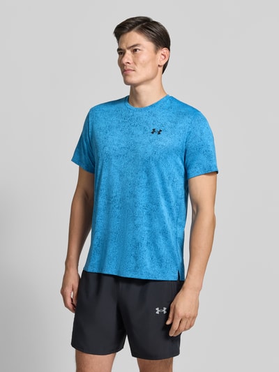 Männermodel trägt Regular Fit Sport-T-Shirt mit Strukturmuster Modell 'Pixelate' von Under Armour in Blau mit schwarzer Shorts, Ganzkörperansicht von vorne. Herren Sport-T-Shirt von Under Armour.