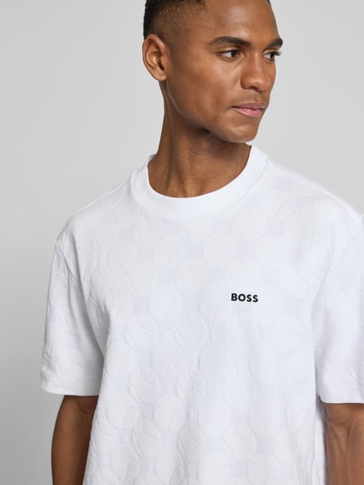 Männermodel trägt weißes Regular Fit T-Shirt aus Baumwoll-Mix Modell 'TS_MEMBER' von BOSS Green mit feinem Strukturmuster, Label Print, Nahaufnahme Oberkörper.