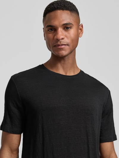Mannelijk model draagt T-Shirt uit linnen-elastaan-mix met ronde hals van OLYMP Level Five, regular fit, labeldetail, close-up bovenlichaam.