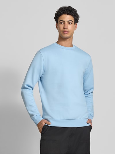 Männermodel trägt Regular Fit Sweatshirt aus Baumwoll-Mix Modell 'CERES' von Only & Sons, hellblau, Rundhals, unifarben, Ganzkörperansicht von vorne.