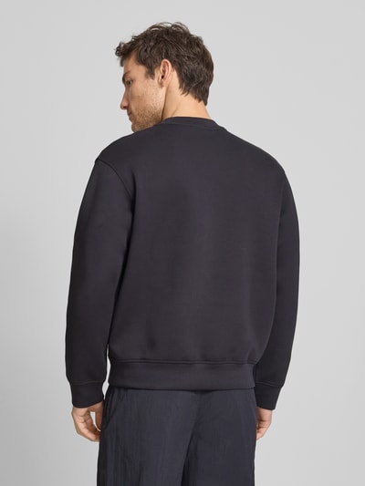 Männermodel trägt Sweatshirt mit Rundhalsausschnitt und Brusttasche von ARMANI EXCHANGE, Baumwoll-Mix mit Stretch-Anteil, Regular-Fit, Rückenlänge 67 cm, Ärmellänge 62 cm, dunkle Farbe, glatte Textur, Ganzkörperansicht Rückansicht.