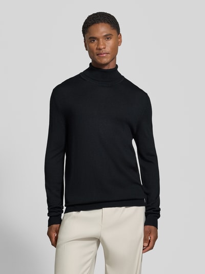 Männermodel trägt Wollpullover mit Rollkragen von Christian Berg Men in Schwarz, gerader Schnitt, gerippte Abschlüsse, Ganzkörperansicht von vorne.