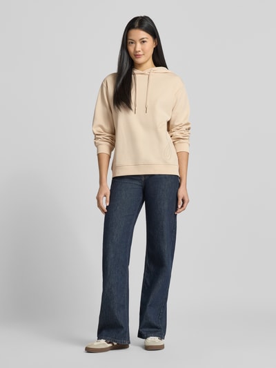 Frauenmodel trägt Hoodie mit Label-Stitching Modell 'Tansu' von JOOP!, Damen, Baumwoll-Mix, Relaxed-Fit, beige, Ganzkörperansicht von vorne.