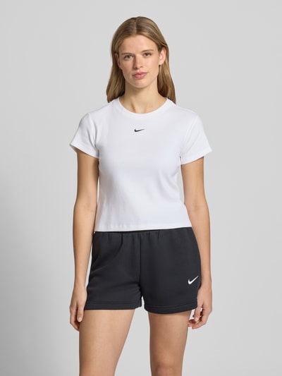 Frauenmodel trägt Cropped T-Shirt in Ripp-Optik mit Logo von Nike aus Baumwoll-Elasthan-Mix mit Rundhalsausschnitt, Ganzkörperansicht von vorne.