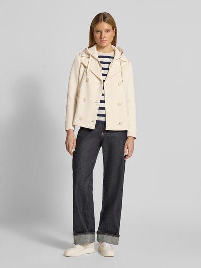 Vrouwenmodel draagt Regular Fit sweatjack met viscose-aandeel van s.Oliver RED LABEL in crème, met reverskraag, capuchon, dubbele knoopsluiting, lange mouw, zij-insteekzakken, materiaalverwerking sweat; volledig lichaamsbeeld van voren.