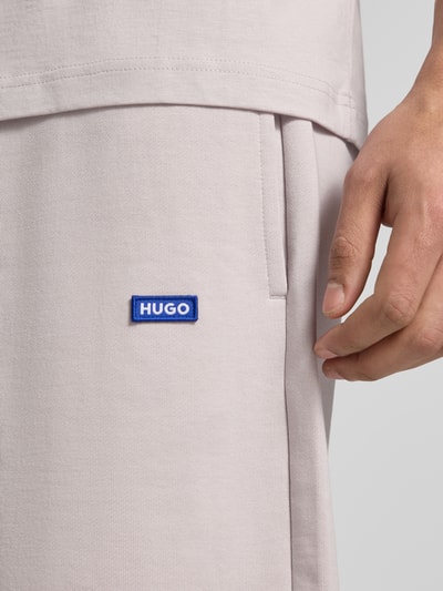 Männermodel trägt Regular Fit Sweatshorts aus reiner Baumwolle Modell 'NASENSIO' von HUGO, Optik: Unifarben, Label-Print, seitliche Eingrifftaschen, Materialverarbeitung: Sweat, Nahaufnahme Oberkörper.