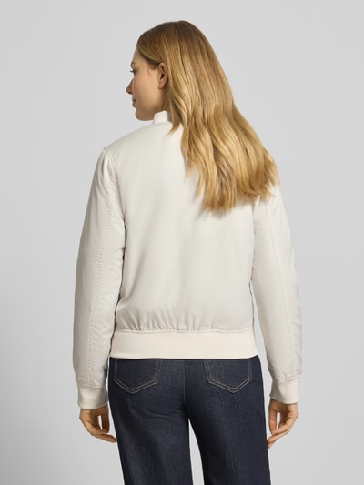 Frauenmodel trägt Regular Fit Jacke mit Stehkragen Modell 'Zaymi' von CARS JEANS, cremefarben mit Elastische Abschlüsse, Reißverschluss, Eingrifftaschen, Rückenlänge 61 cm, Schulterbreite 41 cm, Brustweite 39 cm, Ärmellänge 60 cm, Ganzkörperansicht Rückansicht.