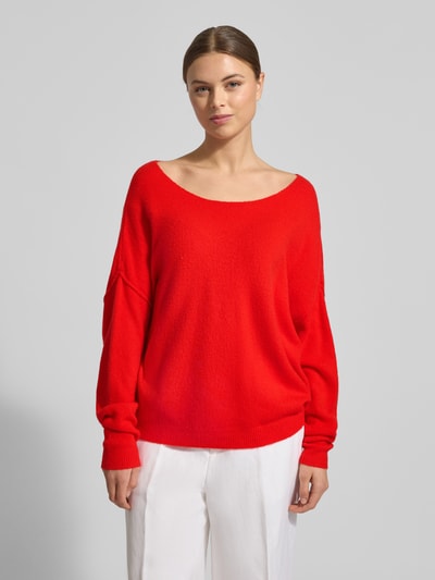 Frauenmodel trägt Oversized Strickpullover mit U-Boot-Ausschnitt Modell 'DAMSVILLE' von American Vintage, leuchtendes Rot, Material-Mix, gerippte Abschlüsse, Ganzkörperansicht von vorne.
