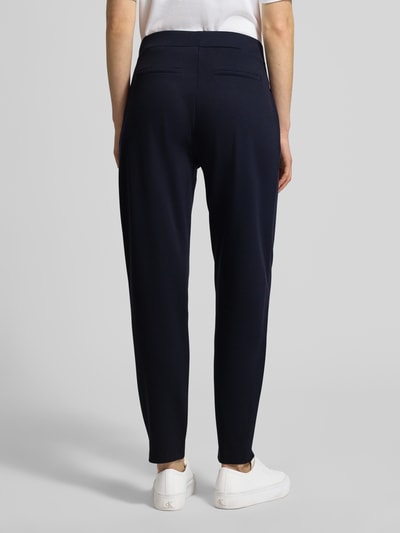 Frauenmodel trägt Jogpants mit elastischem Bund und Tunnelzug von monari aus Material-Mix mit Viskose-Anteil, Regular-Fit, Eingrifftaschen, Farbe Dunkelblau, Ganzkörperansicht Rückansicht.