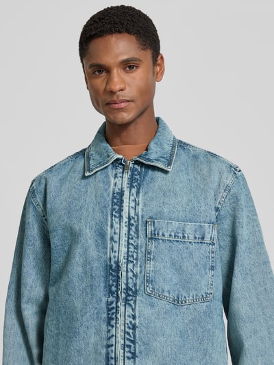 Mężczyzna nosi kurtkę jeansową o kroju regular fit model 'LUNEY BO' z bawełny od BOSS Orange, widok na górną część ciała z przodu