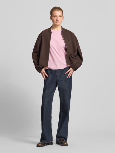 Vrouwenmodel draagt Regular Fit T-Shirt uit pure katoen van TOMMY HILFIGER, effen roze, logo-stitching, ronde hals, korte mouwen, regular fit, materiaal katoen. Vooraanzicht volledige lichaamsopname.