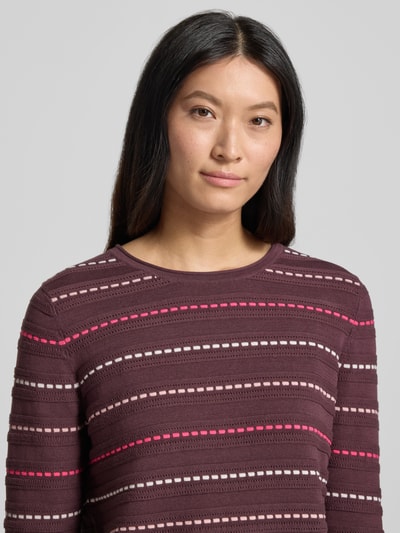 Frauenmodel trägt Strickpullover mit Struktur-Muster von Christian Berg Woman in Braun mit pinken und weißen Streifen, reine Baumwolle, Nahaufnahme Oberkörper.