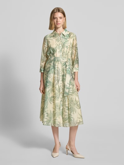 Frauenmodel trägt Figurumschmeichelndes Freizeitkleid aus Lyocell-Mix von s.Oliver BLACK LABEL mit Allover-Muster in Grün-Beige, Knopfleiste, Taillengürtel, V-Ausschnitt, Midi-Länge, 3/4-Arm, Materialverarbeitung Popeline, Viskose-Mix, Ganzkörperansicht von vorne.