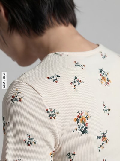 Frauenmodel trägt Regular Fit T-Shirt mit floralem Allover-Print von Jake*s Casual in Creme mit bunten Blumen, Nahaufnahme Rücken. Elastischer Baumwoll-Mix, Rundhalsausschnitt, Rückenlänge bei Größe S 50 cm.