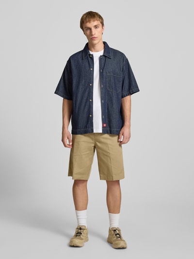 Männermodel trägt Bermudas mit französischen Eingrifftaschen von Dickies, Herren, Reine Baumwolle, Straight, Knopf-Reißverschluss, Ganzkörperansicht von vorne.