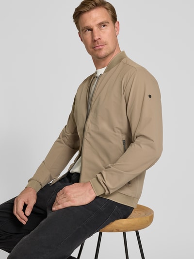 Männermodel trägt Regular Fit Jacke mit Stehkragen Modell 'Campo' von SCANDINAVIAN EDITION, beige, Zweiwege-Reißverschluss, Eingrifftaschen, elastische Abschlüsse, Ganzkörperansicht von vorne. Rückenlänge bei Größe M: 67 cm, Schulterbreite: 44 cm, Brustweite: 51 cm, Ärmellänge: 64 cm.