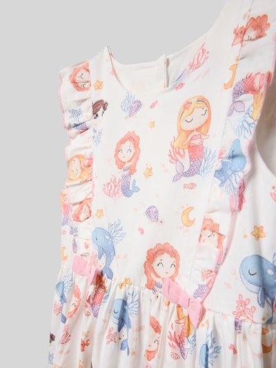 Mädchen trägt Regular Fit Kleid mit Allover-Motiv-Print von Happy Girls aus Reine Baumwolle, mit Rundhalsausschnitt, Rüschenbesatz, Zierschleife, pastellige Farben, Nahaufnahme Oberkörper.