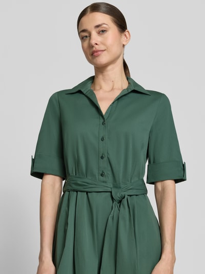 Frauenmodel trägt knielanges Hemdblusenkleid mit Bindegürtel von ROBE LÉGÈRE in Grün, Baumwoll-Mix mit Stretch-Anteil, Nahaufnahme Oberkörper.