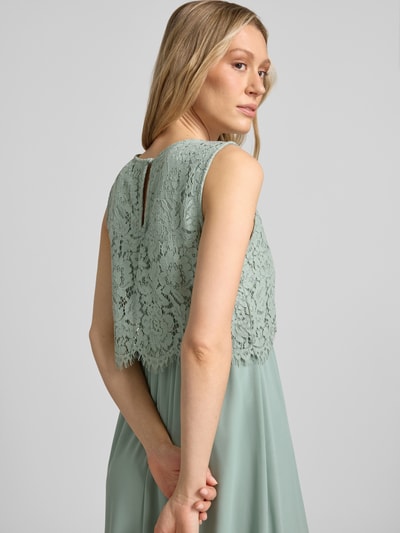 Frauenmodel trägt Maxikleid mit rückseitigem Schlüsselloch-Ausschnitt von Vila, mintgrüner Baumwoll-Mix, Spitze, Ganzkörperansicht Rückansicht.