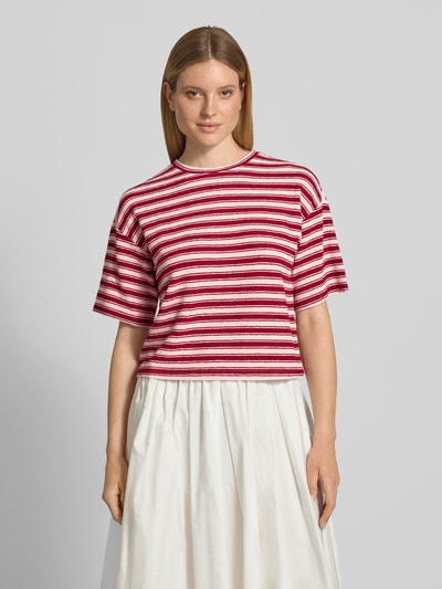 Frauenmodel trägt Oversized T-Shirt mit Strukturmuster Modell 'Cessalia' von MSCH Copenhagen, rot-weiß gestreift, Rundhalsausschnitt, Damen T-Shirt, Rückenlänge 53 cm bei Größe XS/S, Ganzkörperansicht von vorne.
