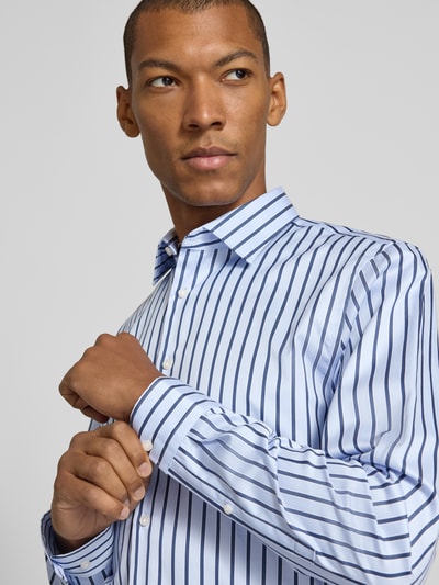 Männermodel trägt Slim Fit Businesshemd aus reiner Baumwolle von Jake*s, hellblau mit dunkelblauen Streifen, Nahaufnahme Oberkörper.