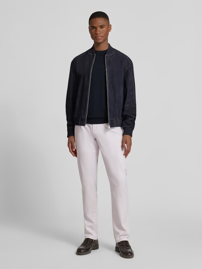 Männermodel trägt Stoffhose mit französischen Eingrifftaschen von MCNEAL, Baumwoll-Elasthan-Mix, gerader Schnitt, helle Farbe, Ganzkörperansicht von vorne.