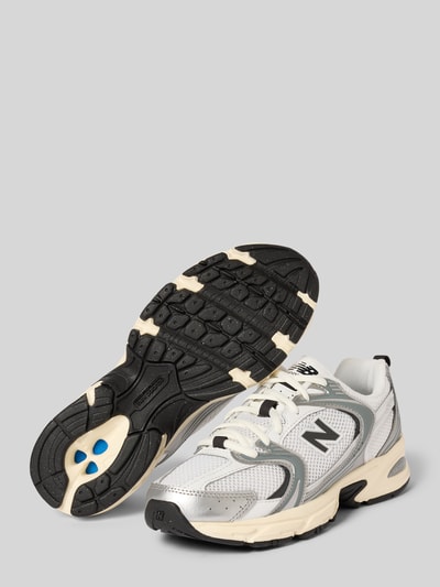 Produktfoto, Sneaker mit Label-Detail Modell 'U530ESA' von New Balance, abgerundete Form, Schnürung, strukturierte Sohle, silberne und weiße Farben, Absatzhöhe 5 cm, Schafthöhe 6 cm, Schaftweite 6 cm.