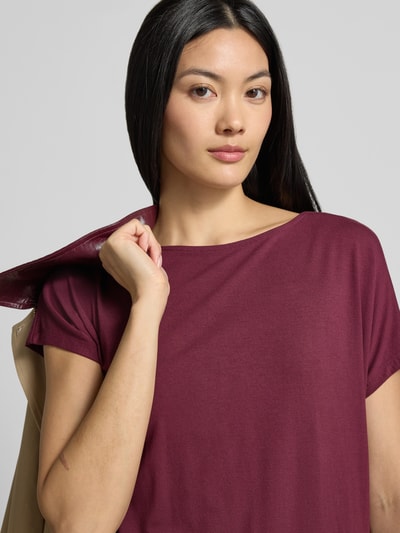 Vrouwenmodel draagt Oversized T-Shirt uit viscose-mix van s.Oliver RED LABEL in bordeaux rood, gladde textuur, close-up bovenlichaam.