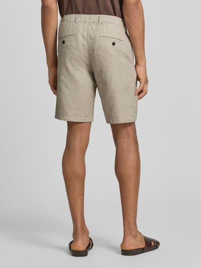 Männermodel trägt Slim Fit Bermudas aus Baumwoll-Leinen-Mix Modell 'BRODY' von SELECTED HOMME, efekt: jednolity kolor, aplikacja z marką, krój slim fit, szlufki na pasek, zapięcie na guzik i zamek błyskawiczny, tunel, wpuszczana kieszeń, kieszeń z tyłu, mieszanka bawełny i lnu, Ganzkörperansicht Rückansicht.