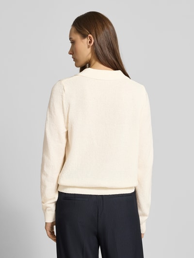 Frauenmodel trägt Langärmliger Polo-Strickpullover aus Bouclé-Garn von Review in Creme, lockere Passform, Polokragen, Strick-Optik, elastische Abschlüsse, Rückenlänge 55 cm, Ärmellänge 65 cm, Ganzkörperansicht Rückansicht.