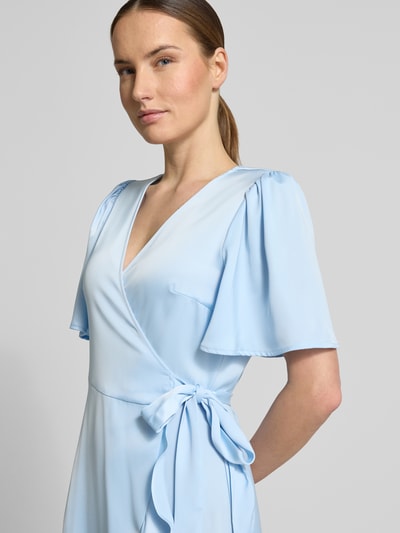 Frauenmodel trägt Cocktailkleid mit Volantsaum Modell 'THEA' von YAS aus hellblauem Satin, taillierter Schnitt, Wickel-Optik, V-Ausschnitt, Schmetterlingsärmel, Nahaufnahme Oberkörper. Rückenlänge bei Größe 36: 120 cm, Brustweite: 39 cm, Ärmellänge: 27 cm.