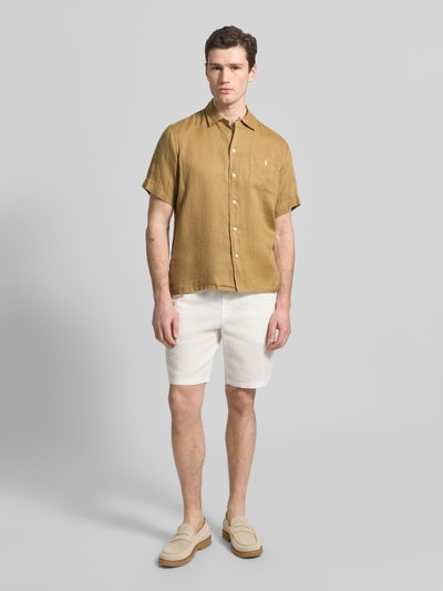 Männermodel trägt Regular Fit Freizeithemd aus reinem Leinen von Polo Ralph Lauren in Unifarbe mit Brusttasche, Flammgarn, Ganzkörperansicht von vorne.