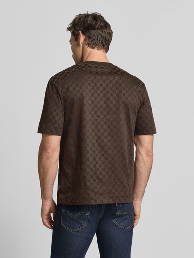 Männermodel trägt Regular Fit T-Shirt aus reiner Baumwolle Modell 'Varo' von JOOP! COLLECTION in Dunkelbraun mit Musterstruktur, Ganzkörperansicht Rückansicht.