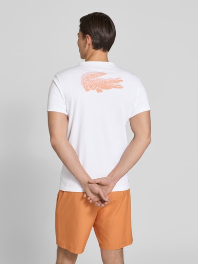 Männermodel trägt Regular Fit T-Shirt aus Baumwoll-Mix von Lacoste mit Optik: Unifarben, Logo-Patch, Rundhals, Kurzarm, Ganzkörperansicht Rückansicht.