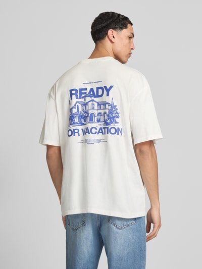 Męski model nosi Oversized T-Shirt mit Label-Detail Modell 'Bovec' od Pegador, bawełna, krój oversized fit, okrągły dekolt, detal z logo, długość tyłu w rozmiarze M: 71 cm, jasny kolor z niebieskim nadrukiem, gładka faktura, pełny widok tyłem.