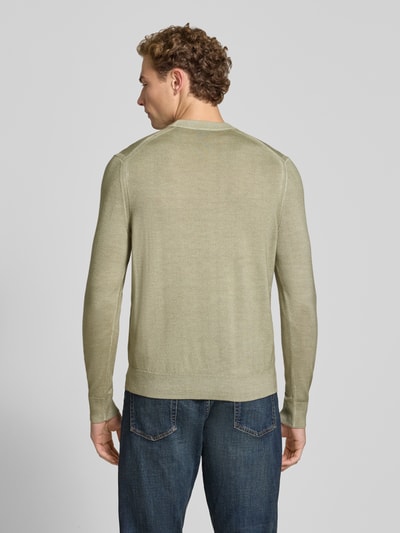 Männermodel trägt Regular Fit Pullover aus reiner Schurwolle Modell 'Kestefo' von BOSS, dezentes Grün, glatte Textur, BOSS Orange, Ganzkörperansicht Rückansicht.