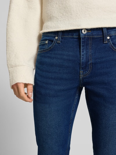Männermodel trägt Slim Fit Jeans aus Baumwoll-Mix Modell 'LOOM' von Only & Sons in Dunkelblau mit 5-Pocket-Design, Nahaufnahme Oberkörper.