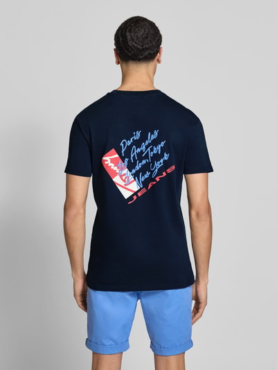 Männermodel trägt Regular Fit T-Shirt aus reiner Baumwolle von Tommy Jeans, Optik: Unifarben, Label-Print, Ganzkörperansicht Rückansicht.