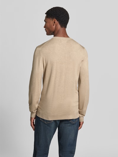 Männermodel trägt Strickpullover mit geripptem Rundhalsausschnitt von MCNEAL in Beige, taillierte Passform, Rückenansicht, Ganzkörperansicht Rückansicht.