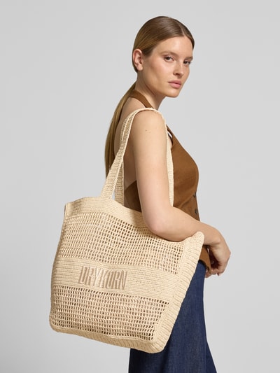 Vrouwenmodel draagt Tote Bag met Label-Detail model 'LAREN' van Drykorn, beige geweven structuur, lange hengsels, zijaanzicht, Nahaufnahme bovenlichaam.