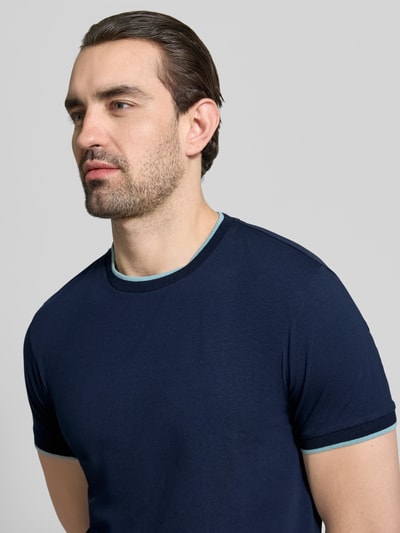 Männermodel trägt T-Shirt mit Rundhalsausschnitt und Kontraststreifen von Manuel Ritz, dunkelblauer Baumwoll-Elasthan-Mix, Nahaufnahme Oberkörper.