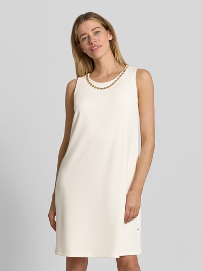 Vrouwenmodel draagt Relaxed Fit jurk met viscose van ROBE LÉGÈRE in crème, mouwloos design, siergarnering, knielengte, ronde hals. Nahaufnahme Oberkörper. Ruglengte maat 36: 94 cm, borstwijdte maat 36: 47 cm.