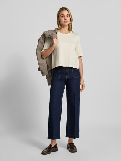 Frauenmodel trägt Wide Fit Jeans aus Baumwoll-Mix Modell 'Jessie' von MANGO in Dunkelblau mit aufgesetzten Taschen, Ganzkörperansicht von vorne. Elastischer Stoff, sichtbare Nähte, Produktkontext: Damen Jeans, Knopf- und Reißverschluss, Bundweite 38 cm, Innenbeinlänge 73 cm.