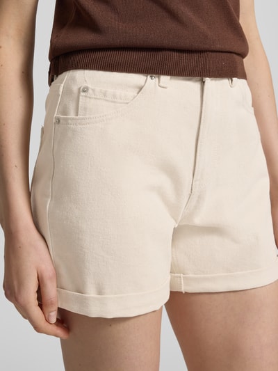 Vrouwenmodel draagt Loose Fit Jeansshorts uit katoenmix model 'ZURI' van Vero Moda in denimlook met labelpatch, 5-pocketmodel, twill, knoop- en ritssluiting, vaste omslag, kleur crème, materiaalverwerking: katoenmix, detailopname heup/been