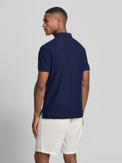 Männermodel trägt Slim Fit Poloshirt aus reiner Baumwolle von Polo Ralph Lauren, Optik: Unifarben, Piqué-Textur, Ganzkörperansicht Rückansicht.